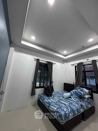 Spacious bedroom with modern design and large windows for natural light.