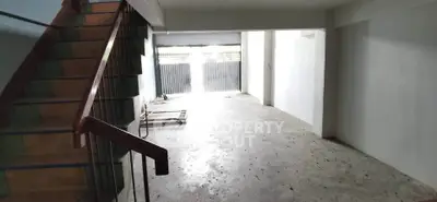 Spacious empty interior with staircase and large windows, ideal for customization.