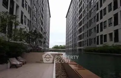 Luxurious apartment complex with serene pool and modern architecture.