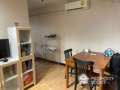 Cozy dining area with wooden table and chairs, air conditioning, and storage cabinet.