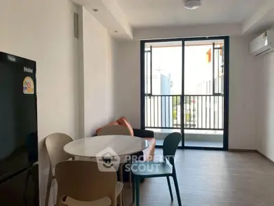 Modern living room with balcony access, featuring sleek furniture and natural light.