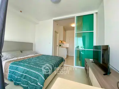 Modern studio apartment with cozy bedroom and open kitchen layout, featuring stylish decor and natural light.