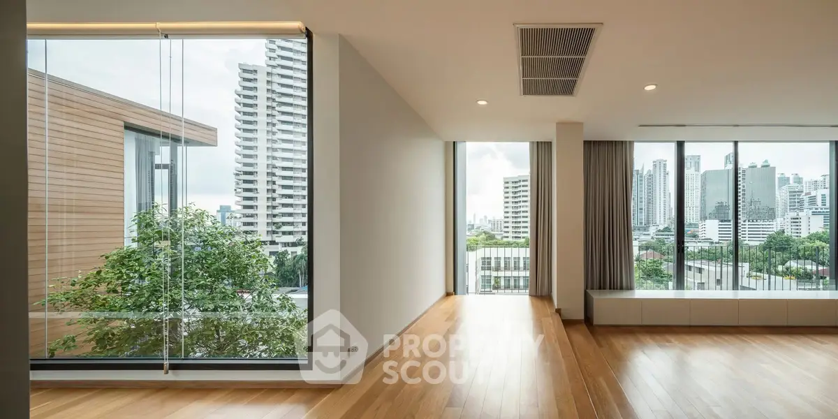 Spacious modern living room with large windows and city view