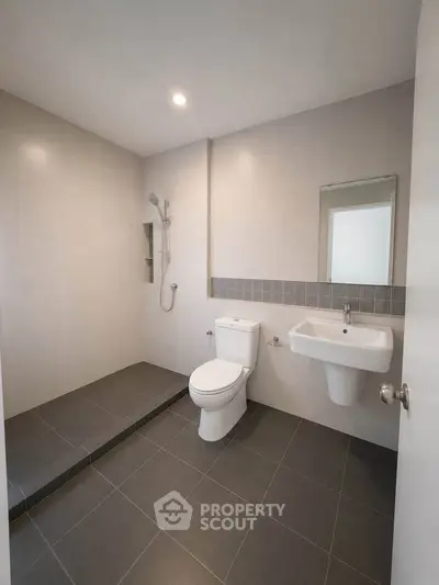 Modern bathroom with sleek design featuring a walk-in shower and contemporary fixtures.