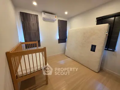 Cozy bedroom with crib and mattress, ideal for a growing family.
