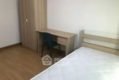 Minimalist bedroom with wooden furniture and mattress, ideal for cozy living.