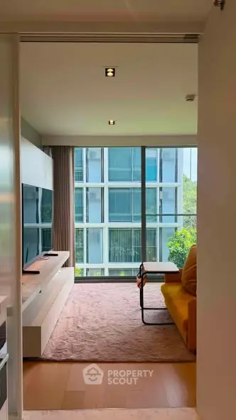 Modern living room with large window and stylish furniture in a high-rise apartment.