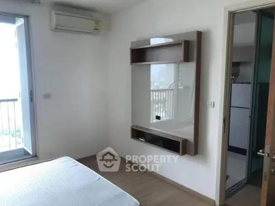 Modern bedroom with balcony access and air conditioning in a stylish apartment.