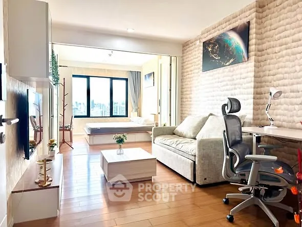 Modern living room with stylish decor and city view, featuring a cozy sofa and sleek workspace.