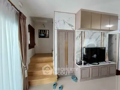 Modern living room with stylish marble TV wall and wooden staircase