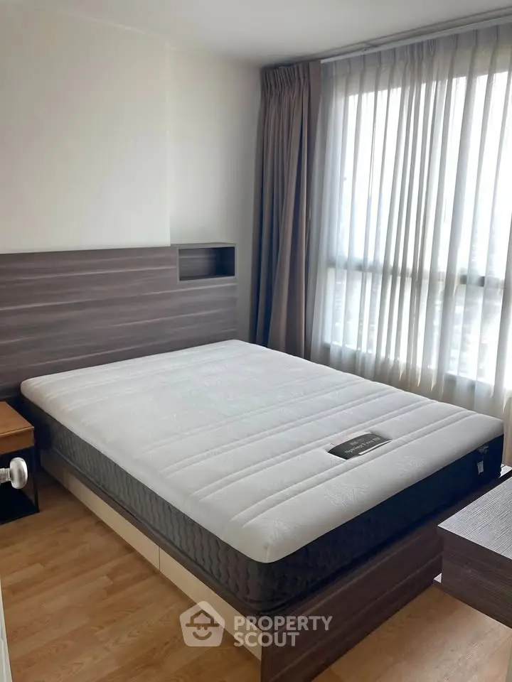 Modern bedroom with large window and stylish wooden furniture, perfect for natural light lovers.