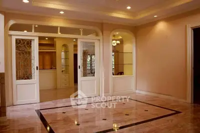 Elegant living room with marble flooring and sliding doors in a spacious interior.
