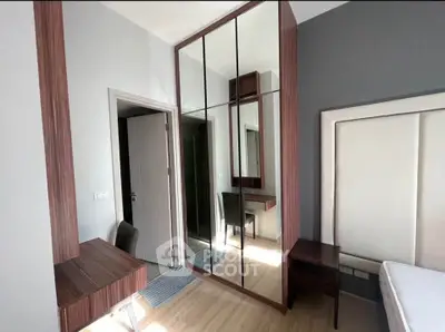 Modern bedroom with mirrored wardrobe and sleek wooden furniture