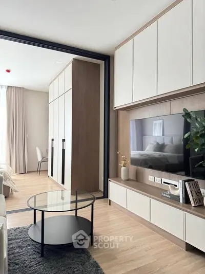Modern living room with sleek furniture and built-in storage, featuring a cozy ambiance.