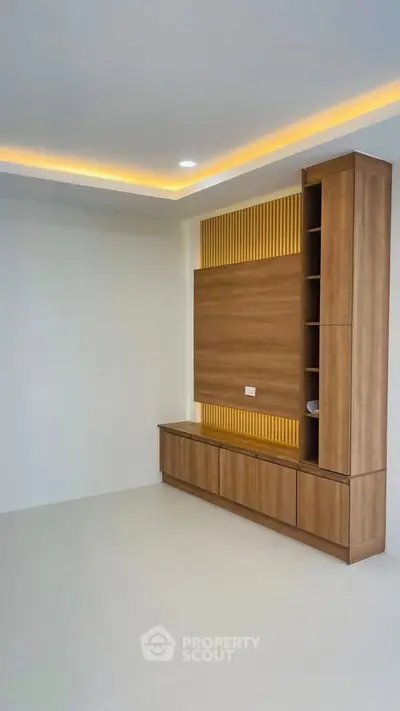 Modern living room with stylish wooden wall unit and ambient lighting