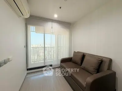 Cozy living room with modern sofa and balcony view, perfect for relaxation.