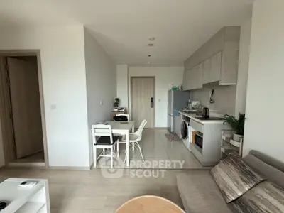 Modern open-plan living room and kitchen with sleek design and natural light.