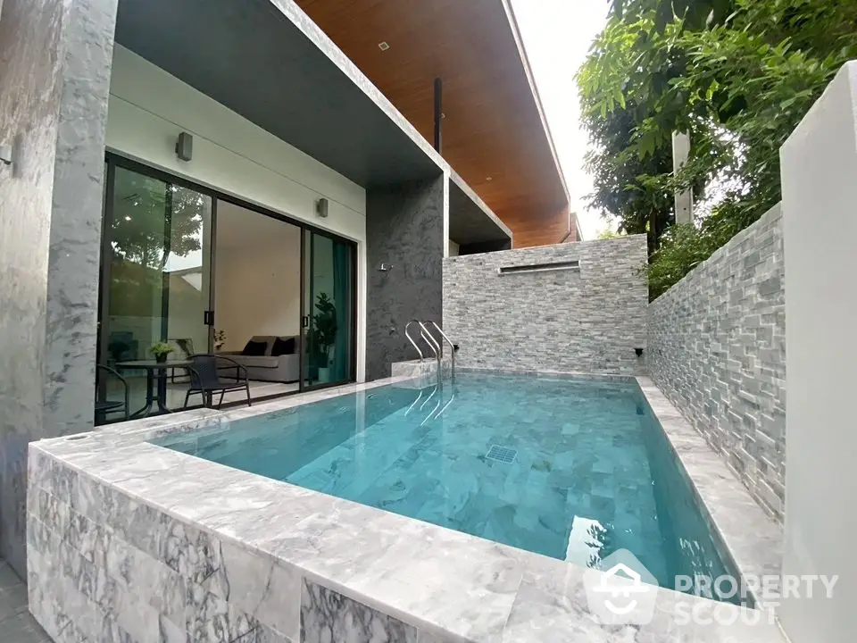 Luxurious modern home with private pool and stylish outdoor seating area.