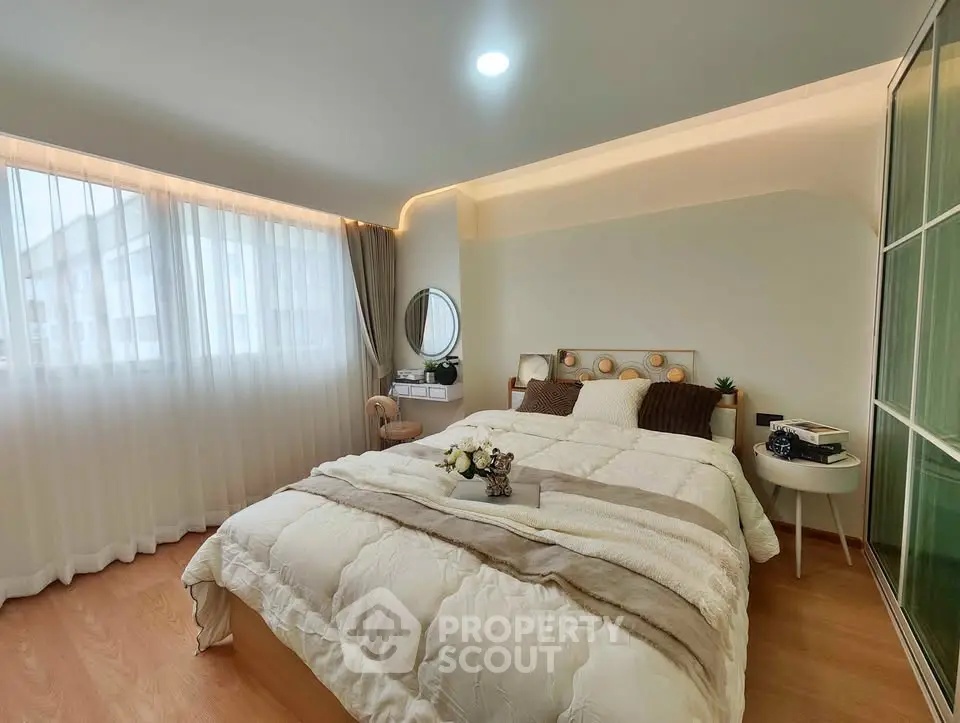 Cozy bedroom with modern decor and ample natural light