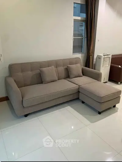 Modern living room with stylish beige sofa and sleek white flooring