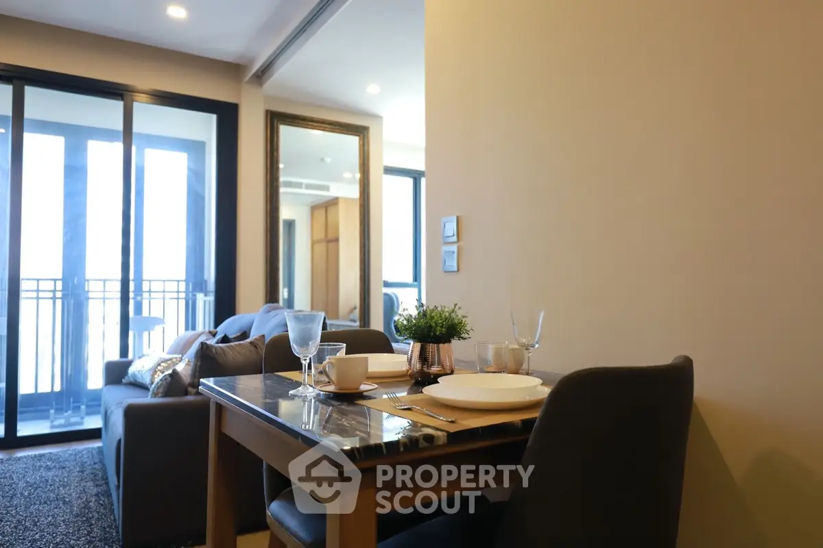 Modern living room with dining area and balcony view in a stylish apartment.