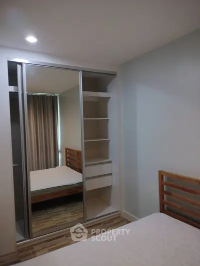 Modern bedroom with mirrored closet and wooden bed frame