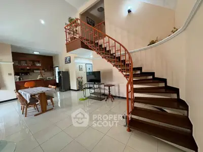 Spacious open-plan living area with elegant spiral staircase and modern kitchen.