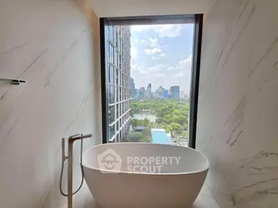 Luxurious bathroom with freestanding bathtub and stunning city view through large window.