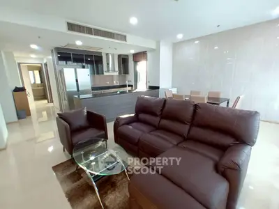 Spacious modern living room with open kitchen and elegant leather furniture