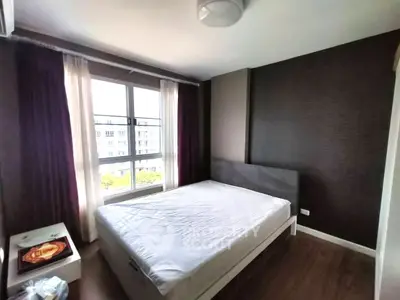 Modern bedroom with large window and stylish decor in urban apartment