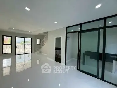 Spacious modern living room with glass partition and sleek white flooring