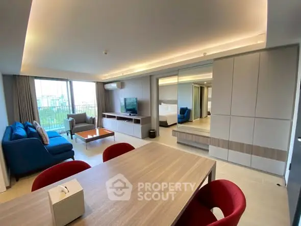 Spacious modern living room with stylish furniture and large windows offering a city view.