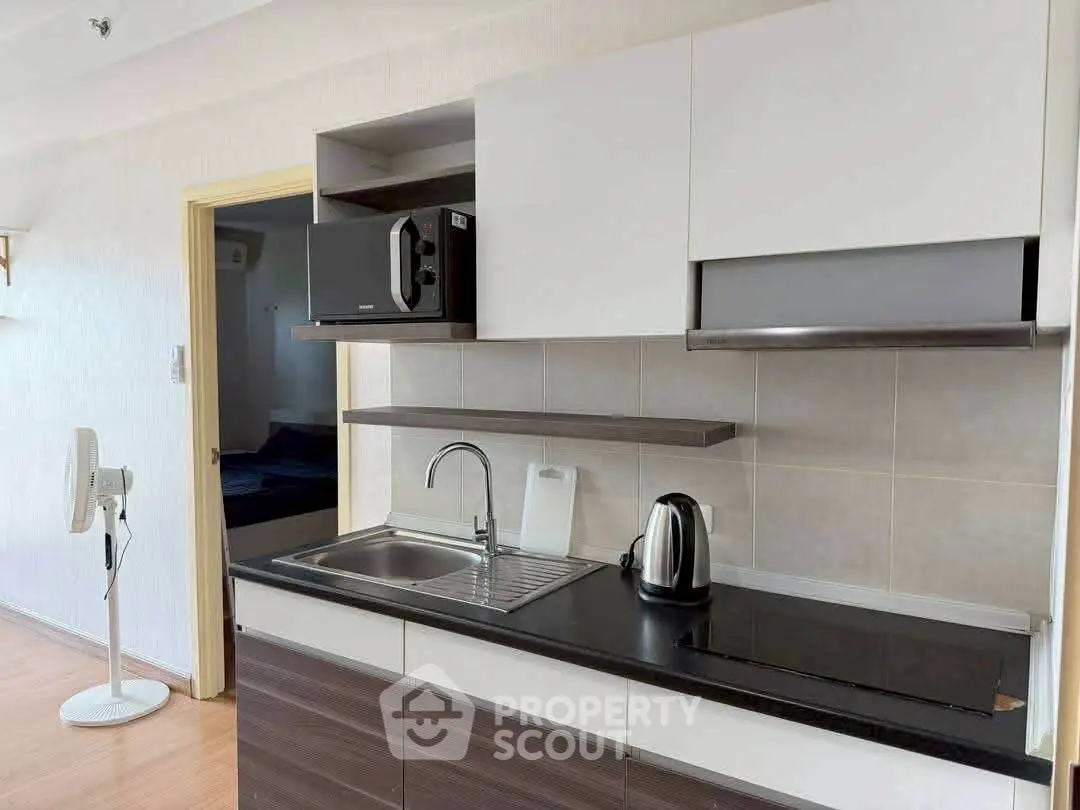 Modern kitchen with sleek cabinetry and appliances in a stylish apartment.