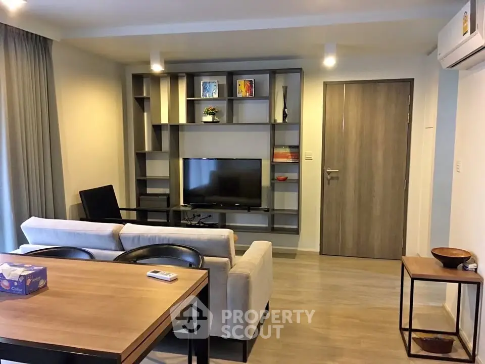 Modern living room with stylish furniture and built-in shelving unit, perfect for cozy gatherings.