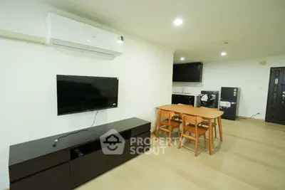 Modern living room with sleek furniture and open kitchen layout in a contemporary apartment.