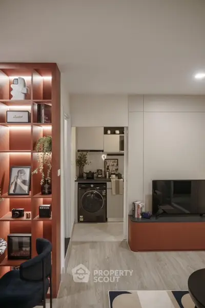 Modern living room with stylish shelving and compact kitchen view