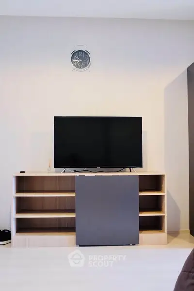 Modern living room with sleek TV stand and wall-mounted clock