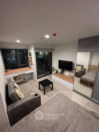 Modern studio apartment with cozy living area and large window view