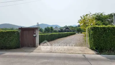 Charming countryside entrance with lush greenery and mountain views