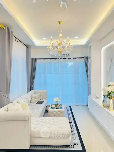 Luxurious living room with elegant chandelier and plush white sofa