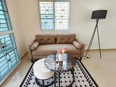 Chic living room with modern sofa, stylish lamp, and elegant decor in bright natural light.