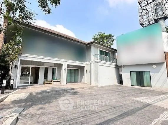 Spacious modern building with large windows and ample parking space, ideal for commercial or residential use.