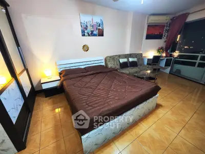 Spacious bedroom with city view, modern decor, and cozy lighting for a comfortable living experience.