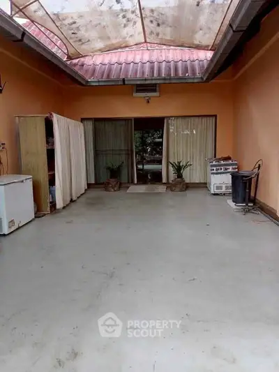 Spacious covered patio with sliding glass doors and natural light, perfect for outdoor gatherings.