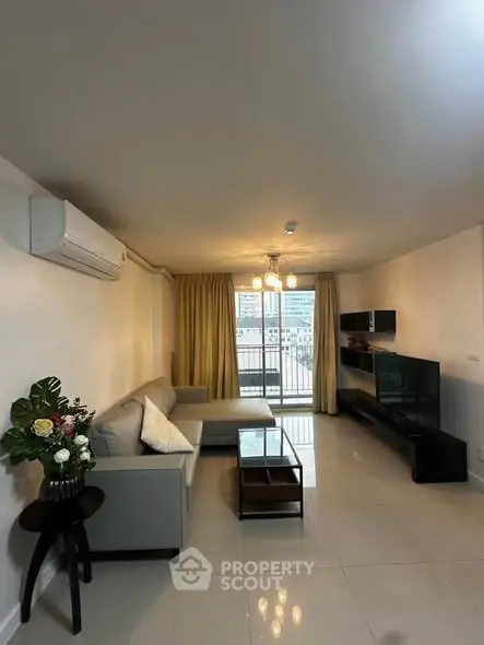 Spacious living room with modern decor and balcony view in a stylish apartment.