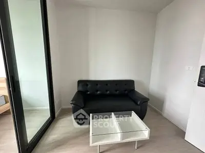 Modern minimalist living room with black sofa and glass coffee table