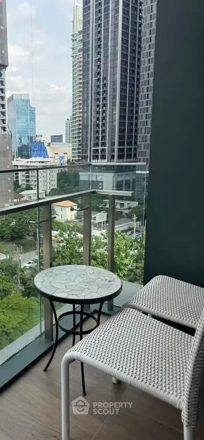 Stunning city view from a modern balcony with stylish outdoor seating.