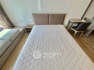 Modern bedroom with stylish furniture and natural light, featuring a comfortable bed and workspace.