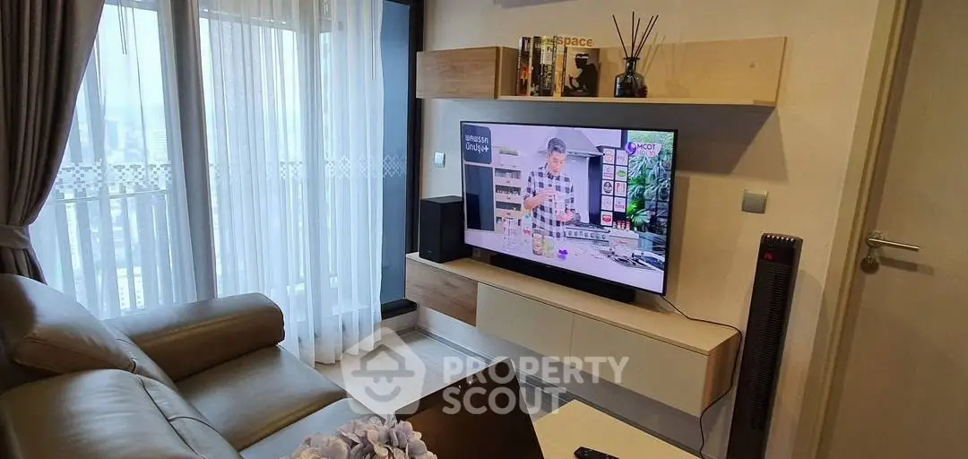 Modern living room with sleek TV setup and cozy seating area.