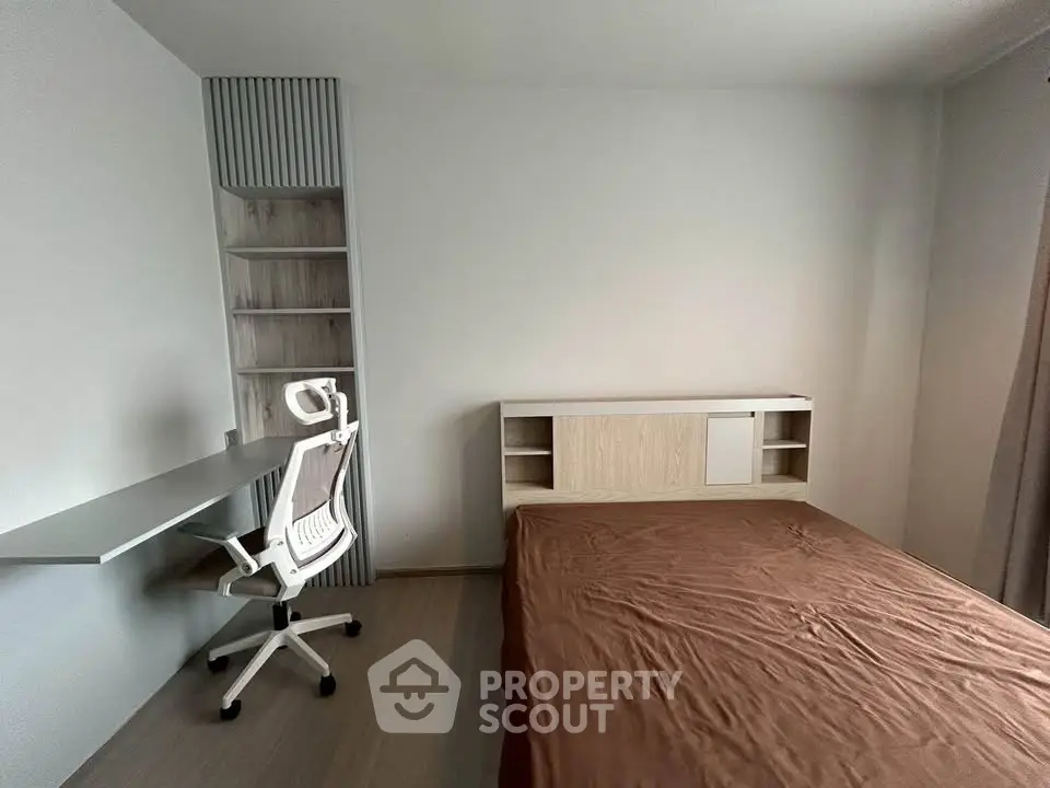 Modern minimalist bedroom with sleek desk and ergonomic chair, perfect for a productive home office setup.